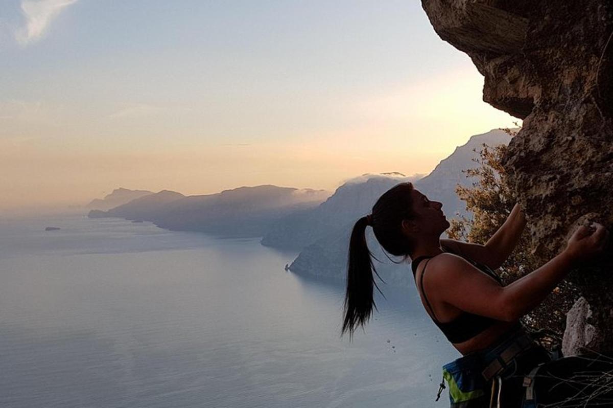 una donna che scala una scogliera che domina l'oceano