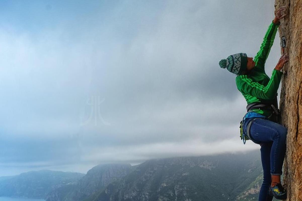 una persona su una roccia che scala una montagna