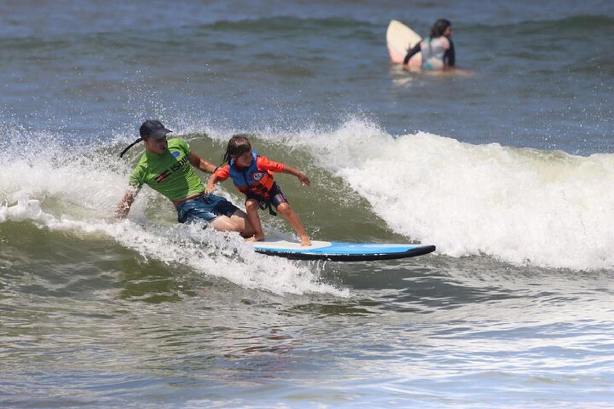 zwei Personen, die auf einem Surfbrett im Meer auf einer Welle reiten