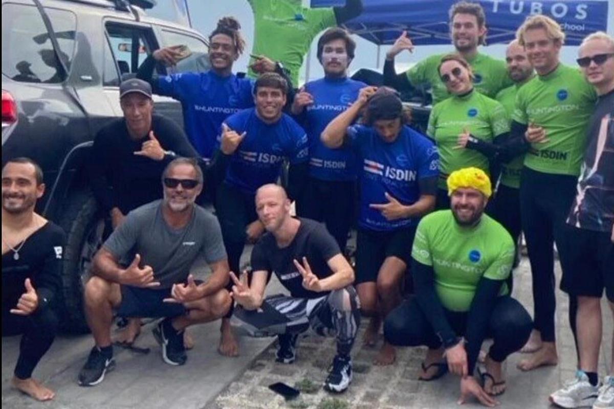 eine Gruppe von Männern posiert für ein Foto vor einem Auto