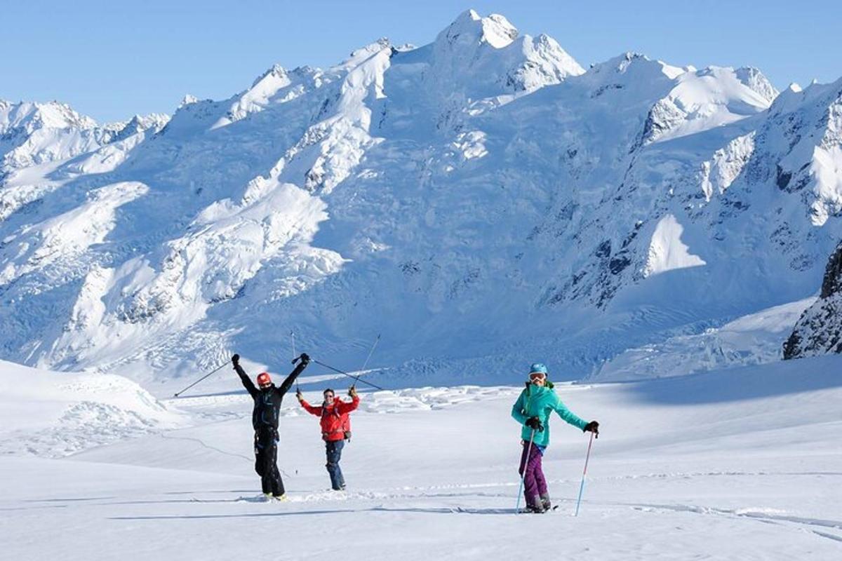 Tres personas de pie en la cima de una montaña cubierta de nieve