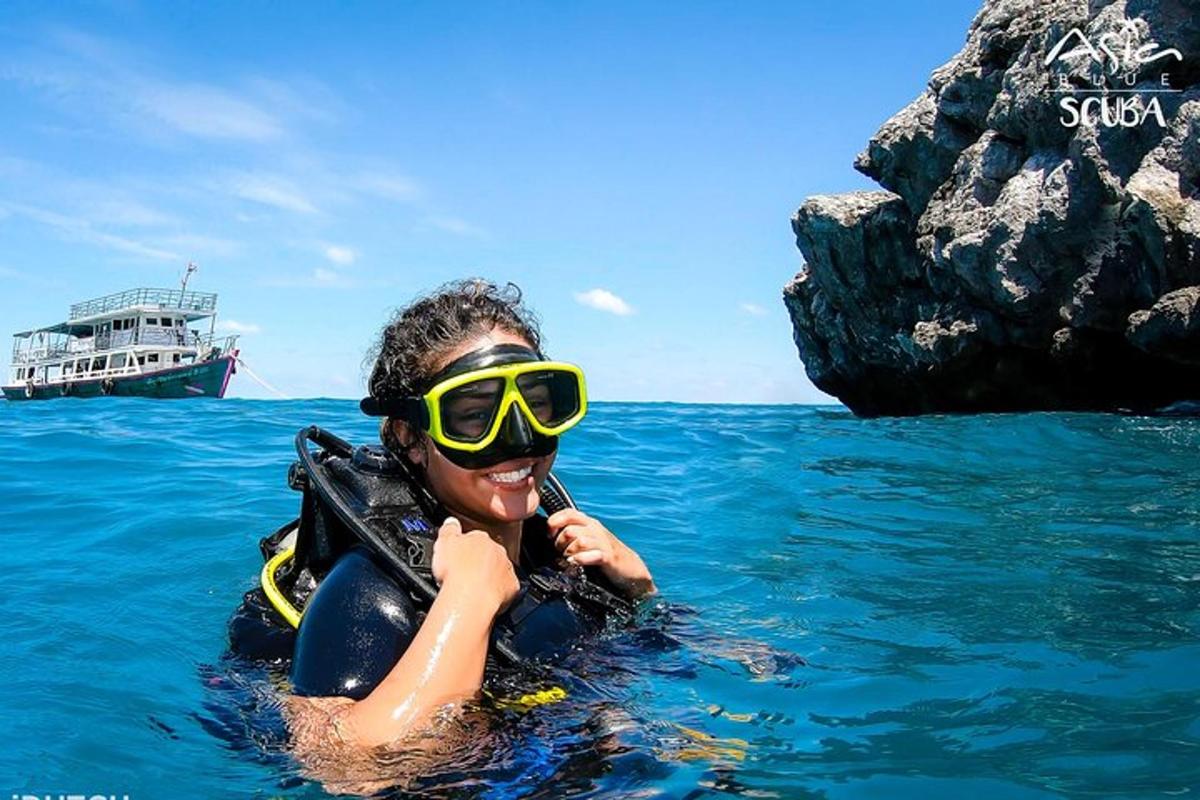 Una mujer con gafas en el agua con un bote.