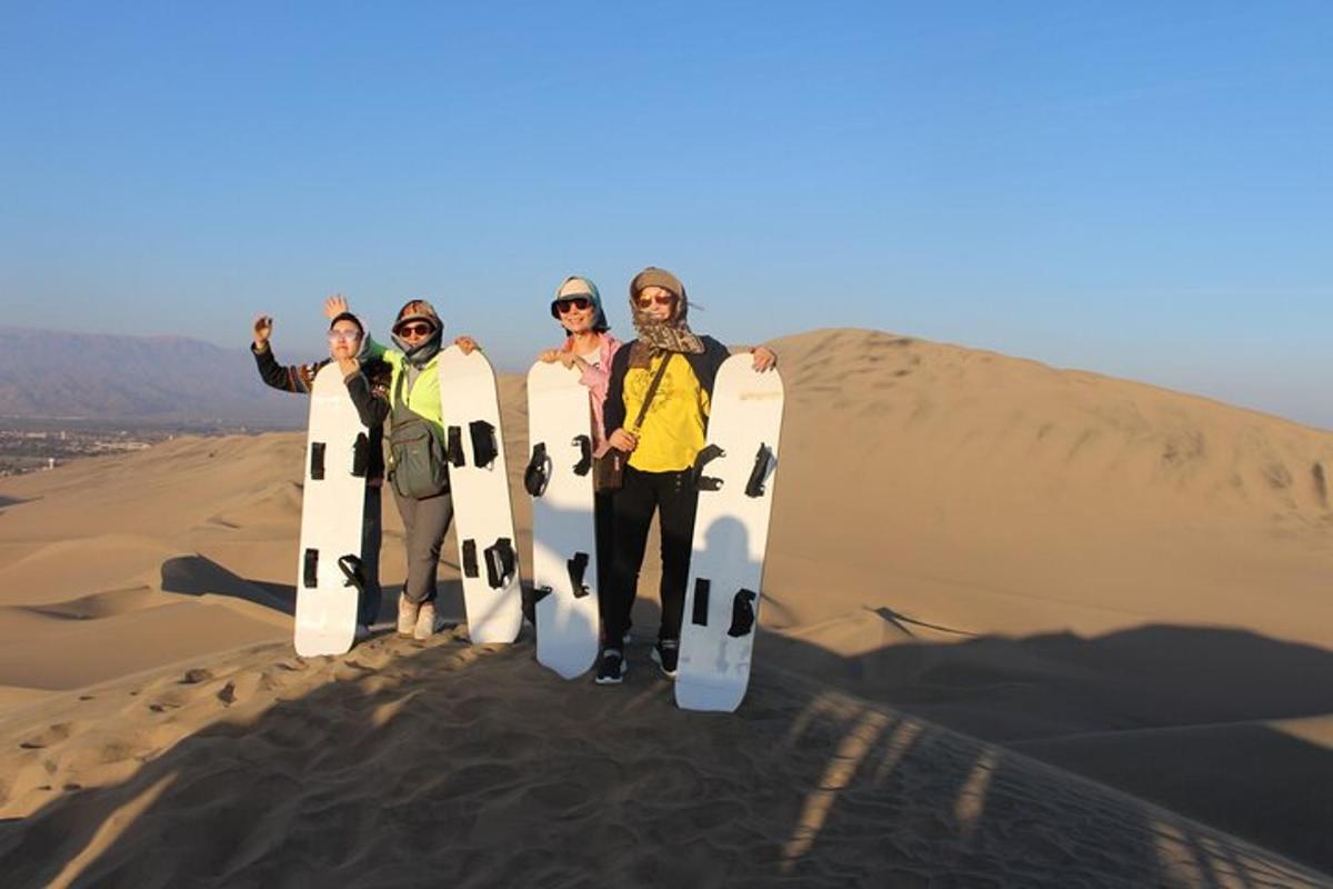 un grup de oameni care stăteau în deșert ținând în mână plăci de snowboard