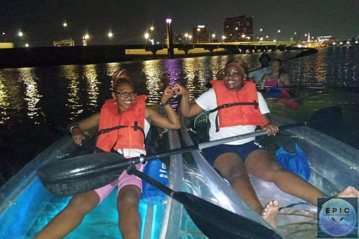 two girls kayaking on the river at night