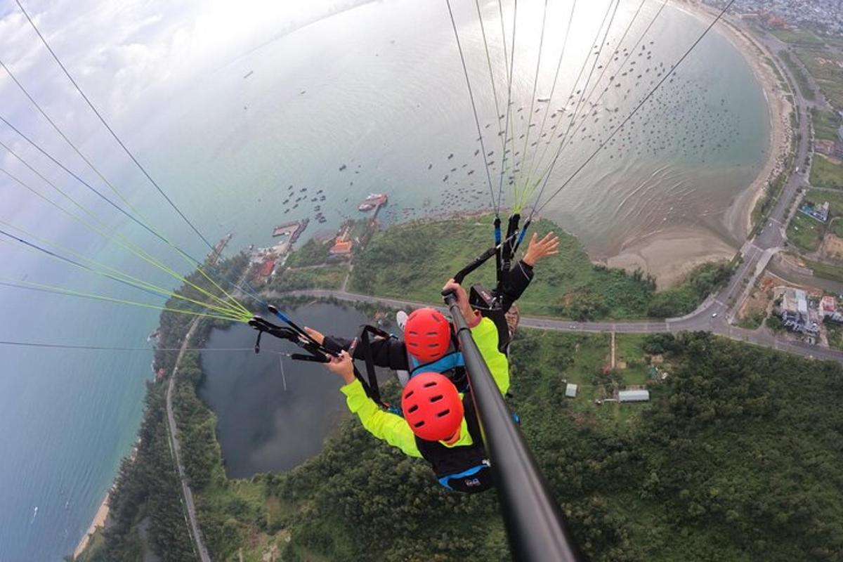 two people are hanging from a parachute over a lake