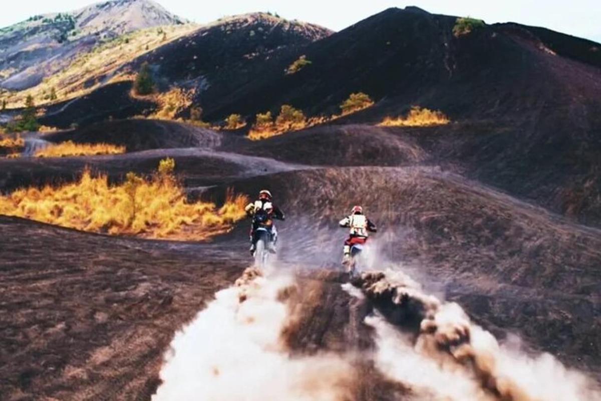 dua orang menunggang motosikal di jalan tanah