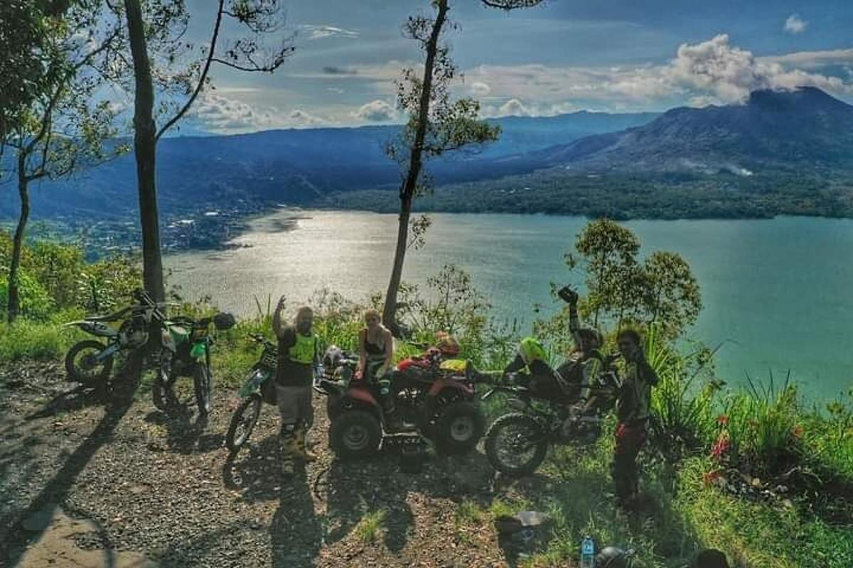 sekumpulan orang berdiri di atas bukit di sebelah tasik