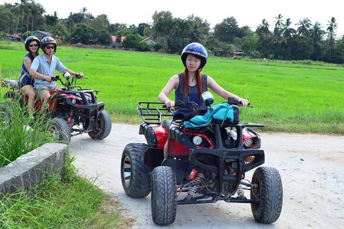 Tres personas viajando en vehículos todo terreno por un camino de tierra