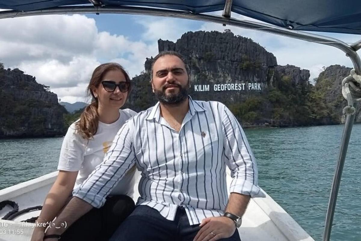 seorang lelaki dan wanita duduk di atas bot di dalam air
