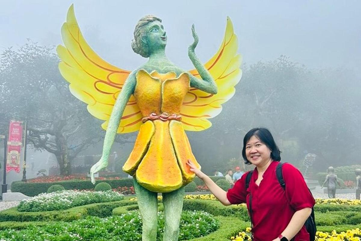 una donna in piedi accanto alla statua di una fata