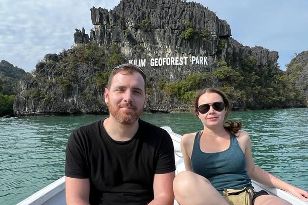 a man and a woman sitting on a boat in the water