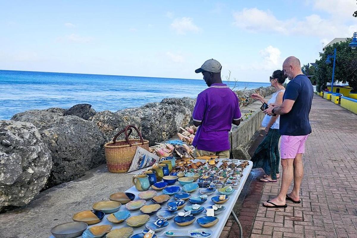 a group of people standing next to a table with pottery