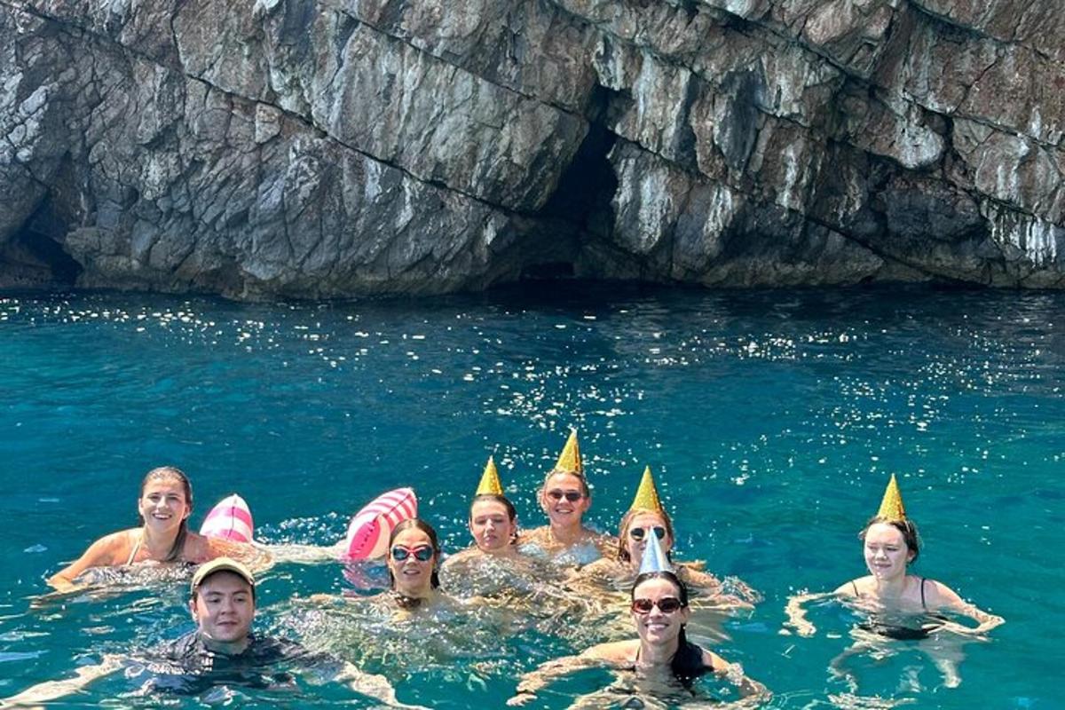 skupina ljudi v vodi, ki nosijo stožčaste klobuke
