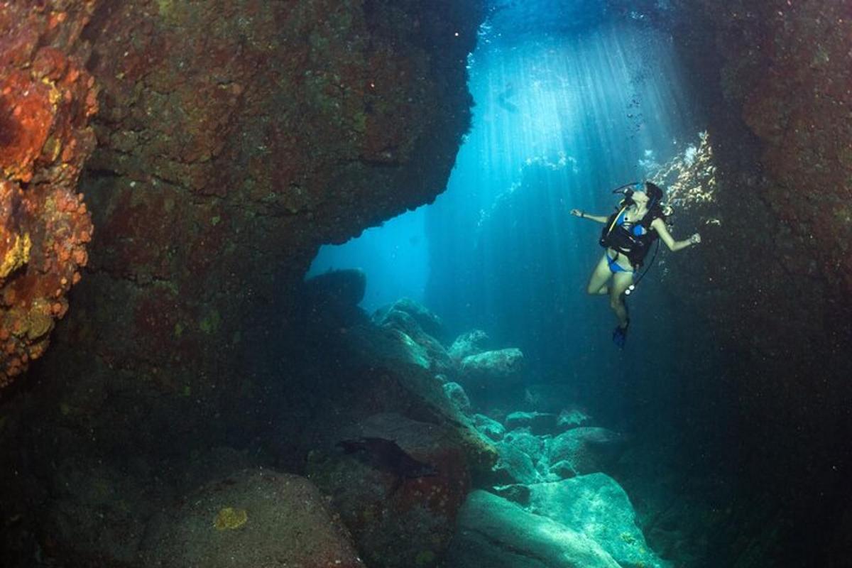 una dona submergint-se en una cova a l'oceà