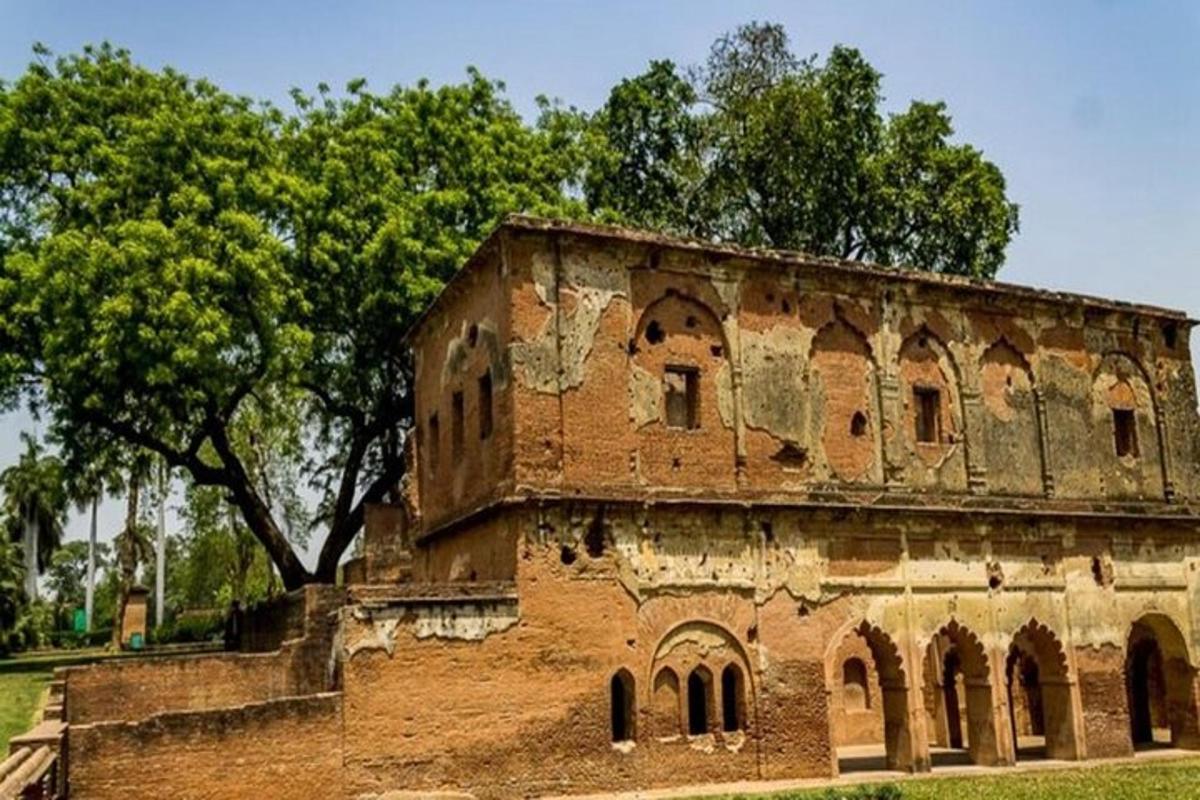 an old brick building with trees in the background