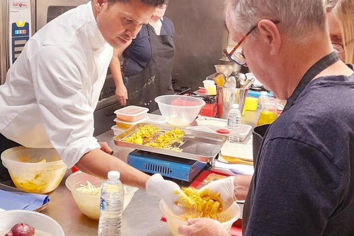 two people standing in a kitchen preparing food
