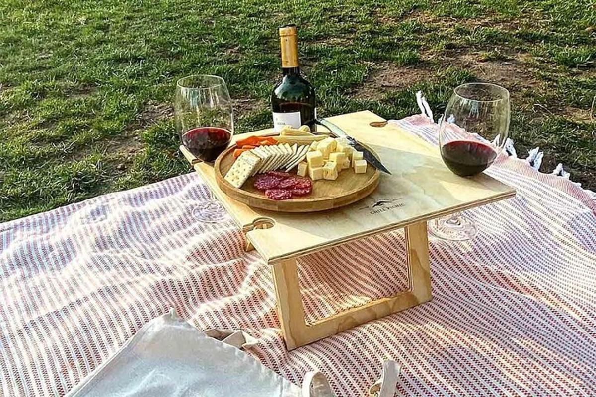 o masă de picnic cu o farfurie de brânză și vin