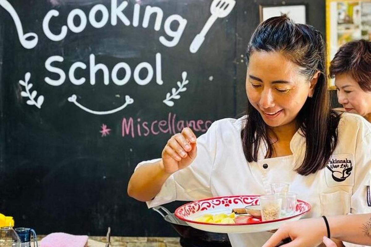 a woman holding a plate of food in front of a chalkboard