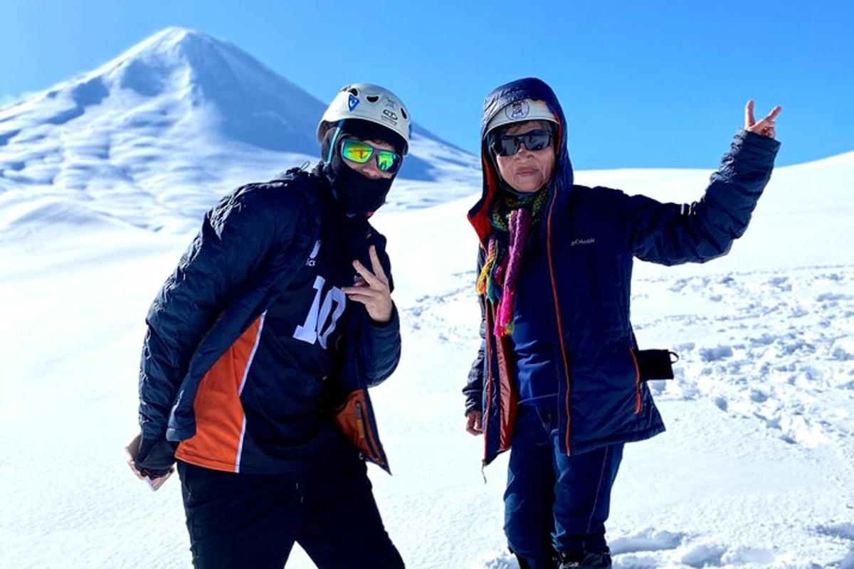 dva lidé stojící na vrcholu zasněžené hory