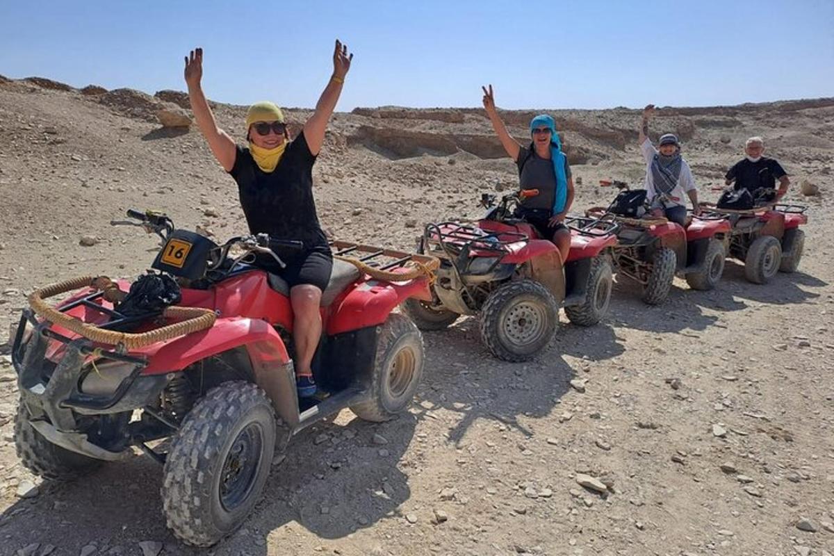 sekelompok orang mengendarai ATV di padang pasir