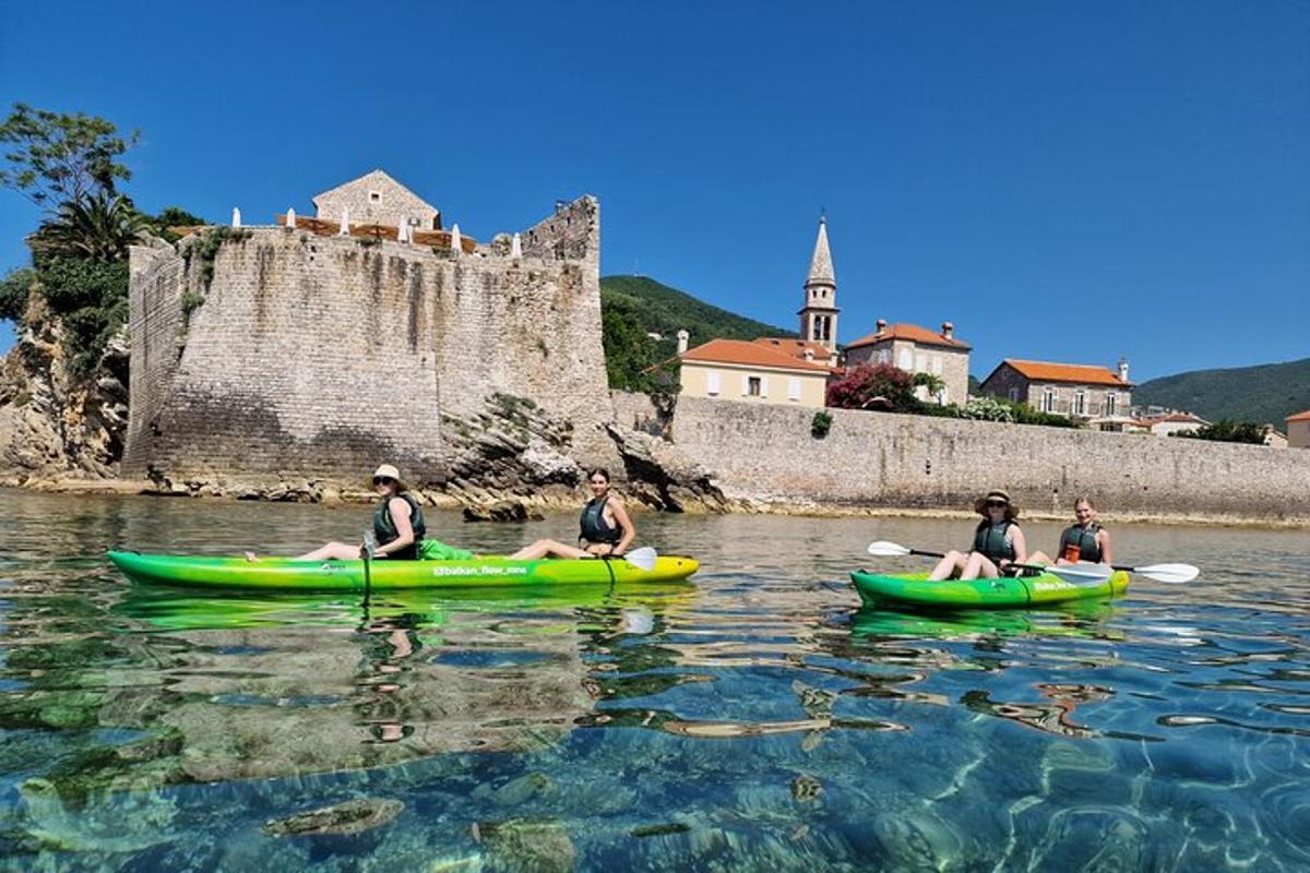 un gruppo di persone in kayak nell'acqua vicino a un castello