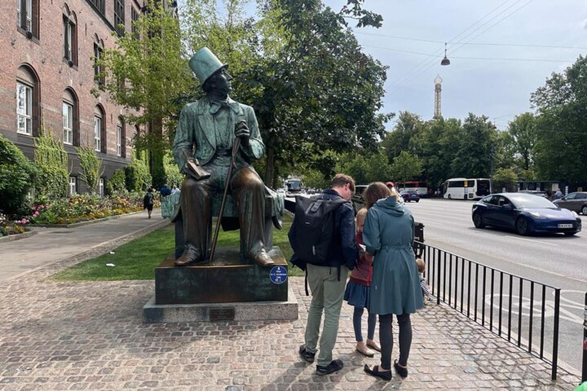Un grupo de personas de pie junto a una estatua