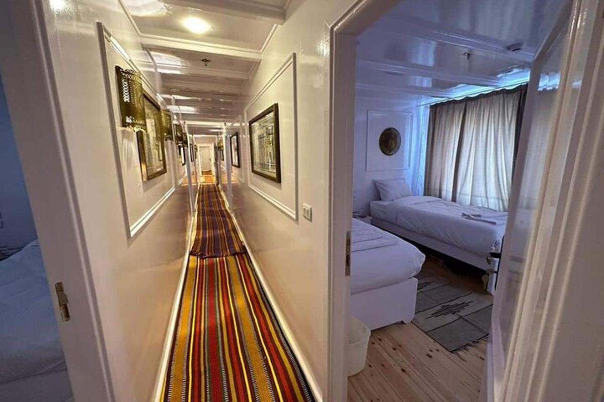 ein Flur eines Kreuzfahrtschiffes mit einem Zimmer mit zwei Betten