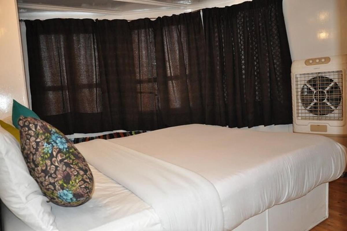 una camera da letto con un letto bianco con tende nere