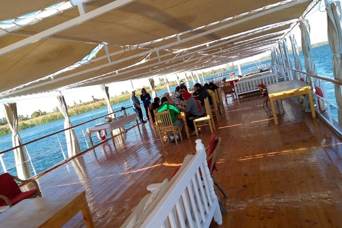 un gruppo di persone sedute sul ponte di una barca