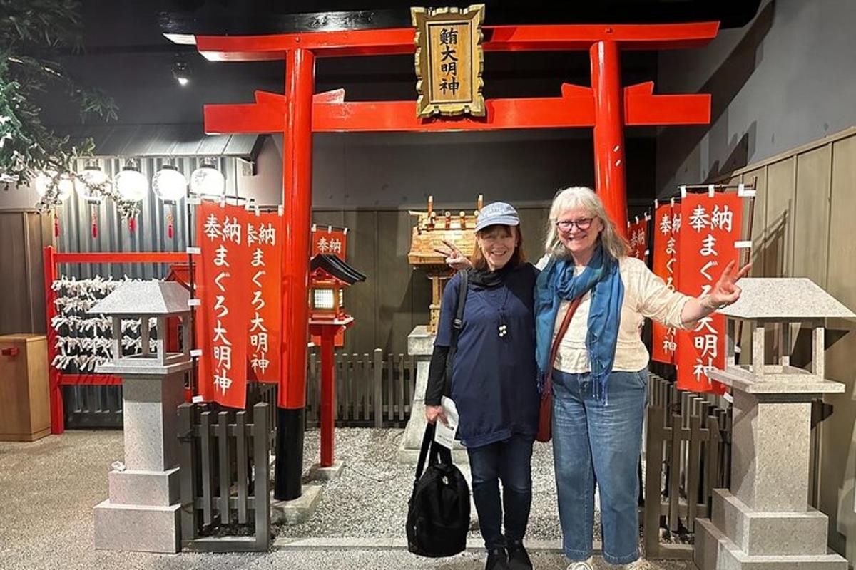 两名女子站在红色鸟居门前