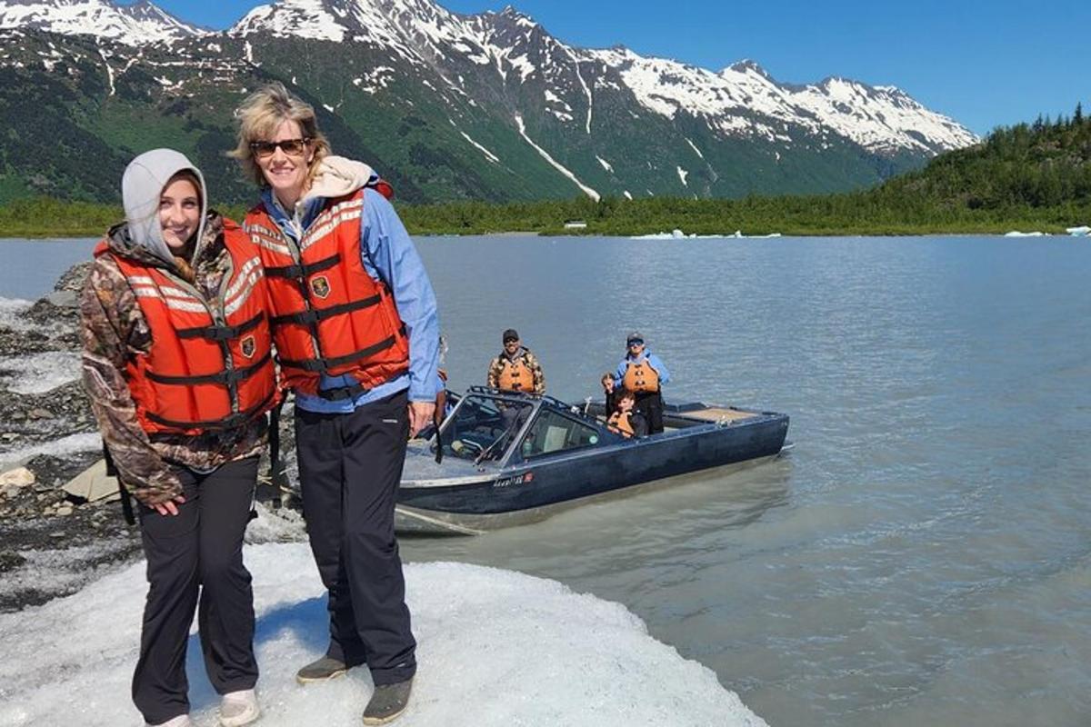 a man and woman standing next to a boat on a lake