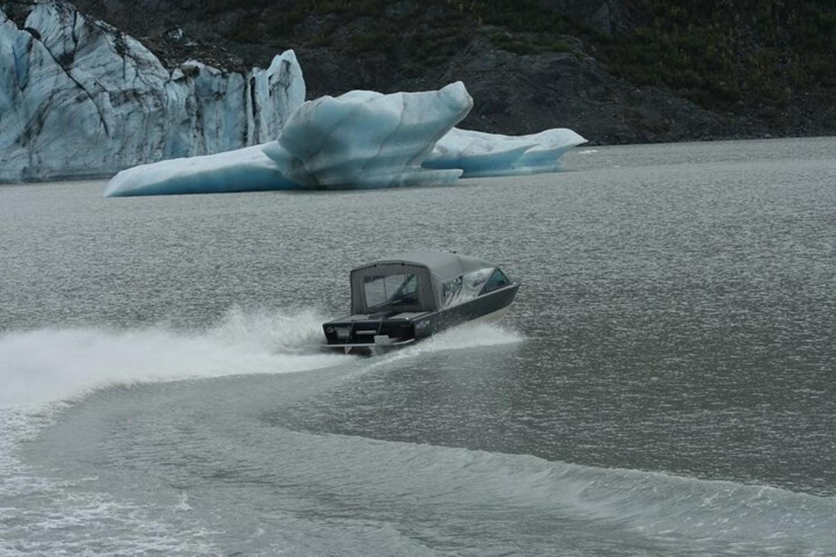 a boat in the water next to an iceberg