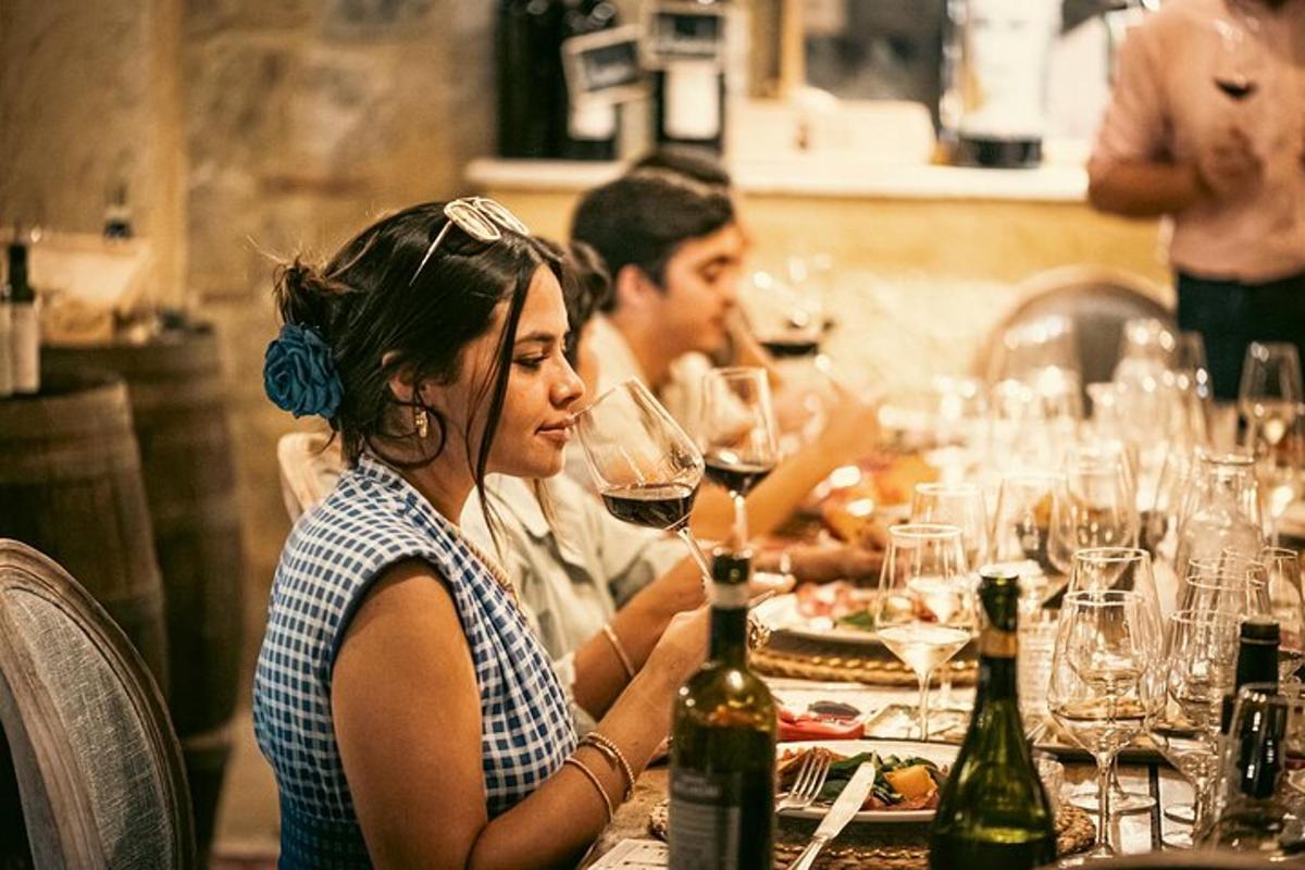 a woman sitting at a table with a glass of wine
