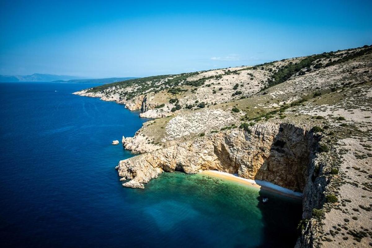 an aerial view of a rocky shore with blue water