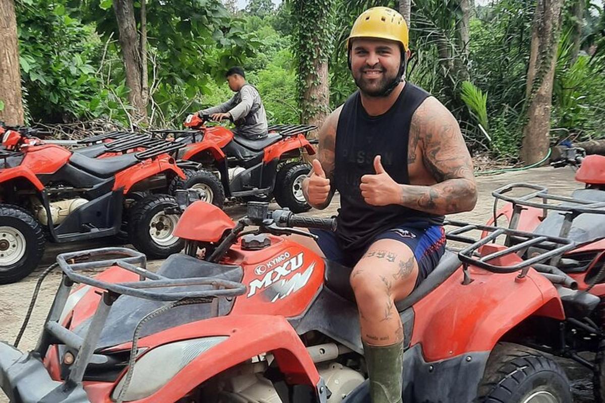 un home aixecant el polze mentre està assegut en un quad