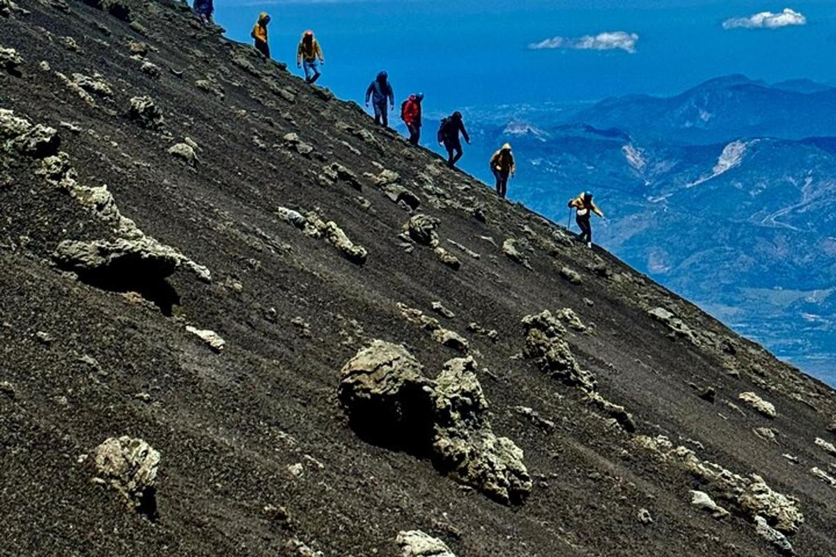 un grup de oameni care urcă pe coasta unui munte