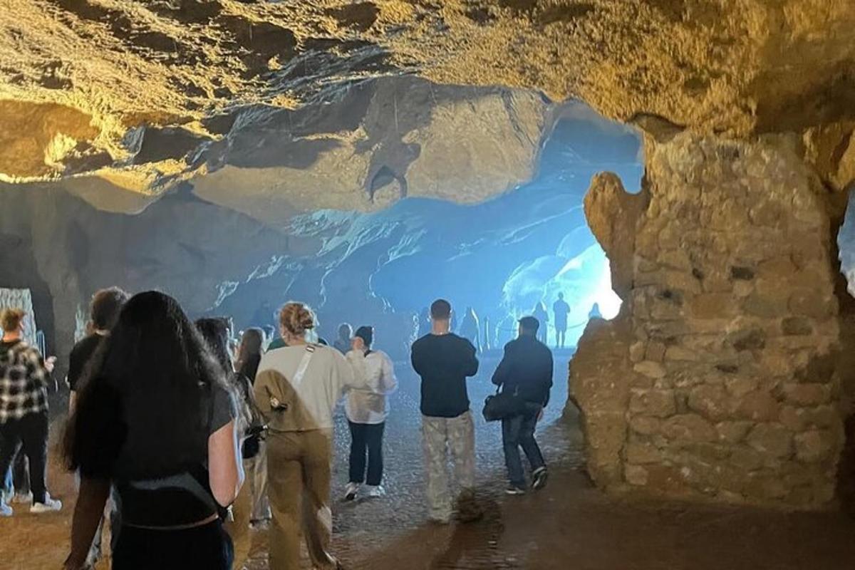 cilvēku grupa, kas stāv lielā alā