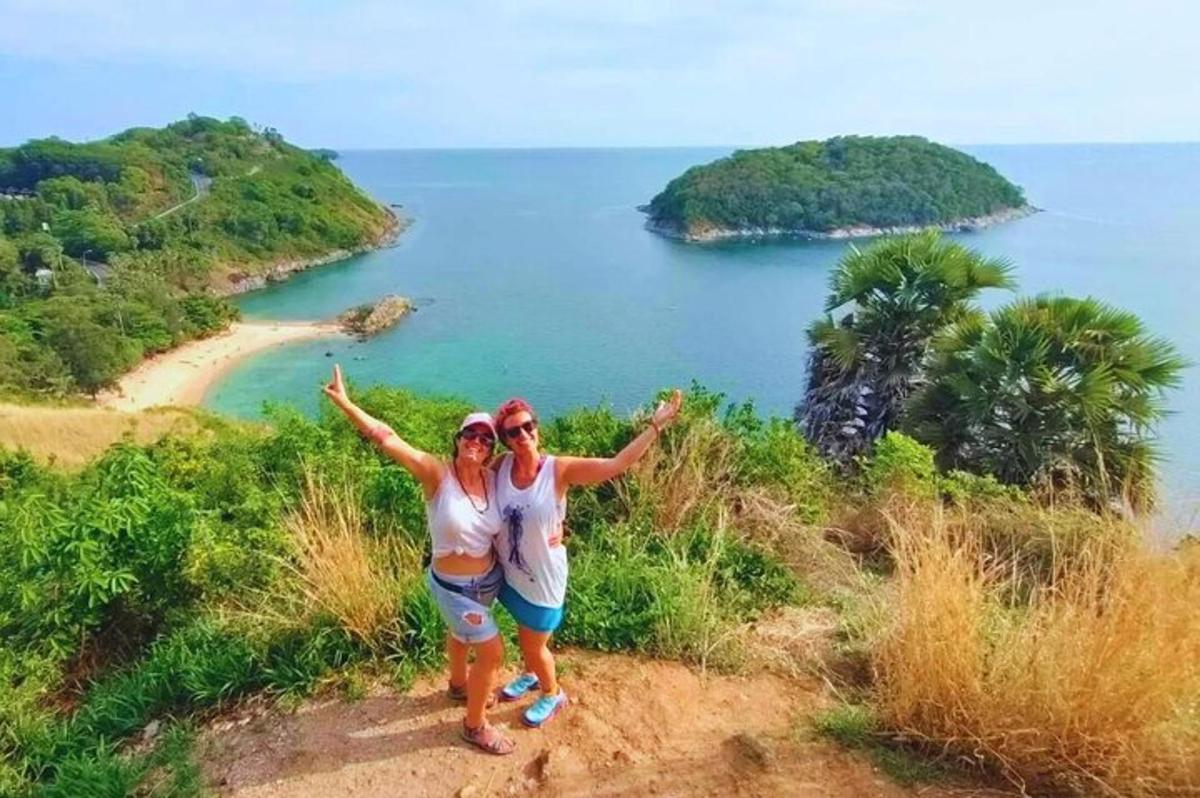 dua wanita berdiri di atas bukit dekat laut
