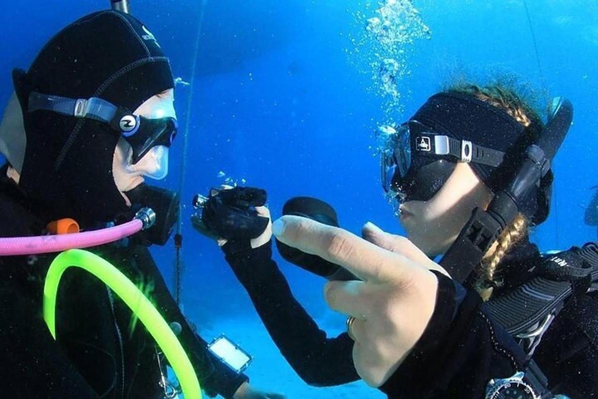 Δύο άτομα με καταδυτικό εξοπλισμό φωτογραφίζουν έναν δύτη