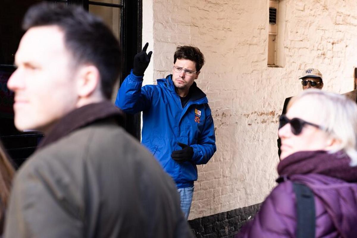 un uomo con una giacca blu in piedi accanto a un muro