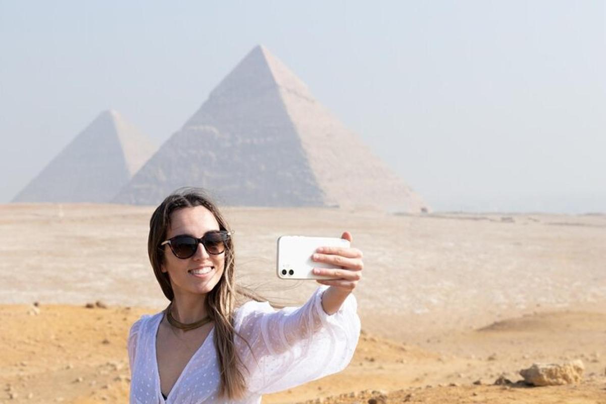una donna che scatta una foto davanti alle piramidi