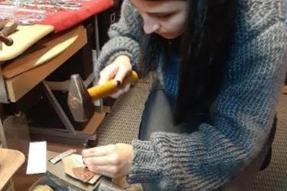 a young girl cutting a sandwich with a knife