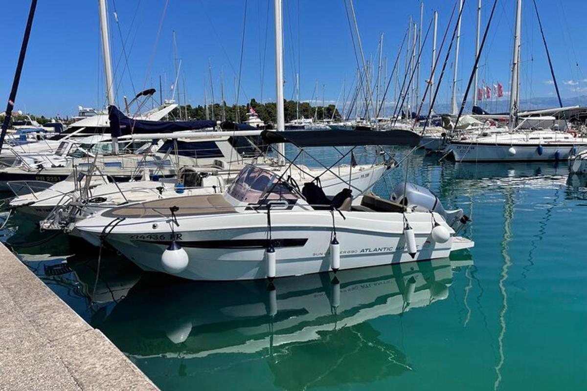 una barca bianca attraccata in un porto turistico con altre barche