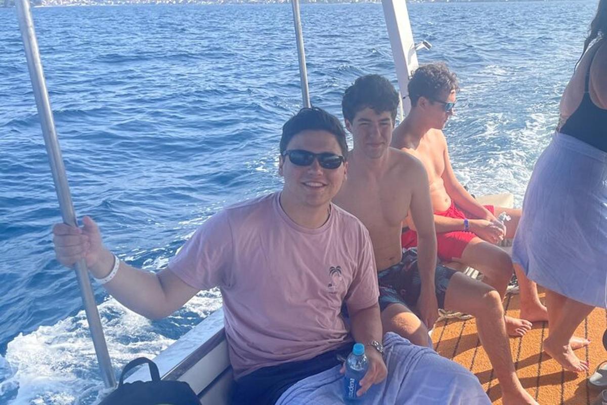 tre uomini seduti su una barca in acqua