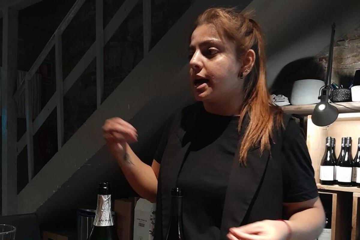 žena stojaca v miestnosti s fľašami vína