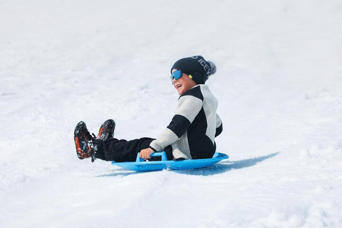 Mladý chlapec jede na snowboardu po zasněženém svahu