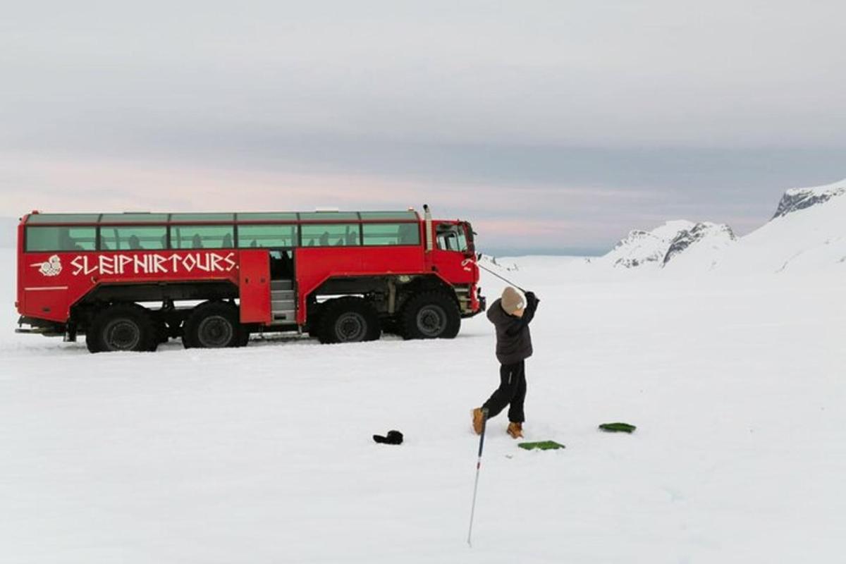 una persona in piedi accanto a un camion rosso nella neve