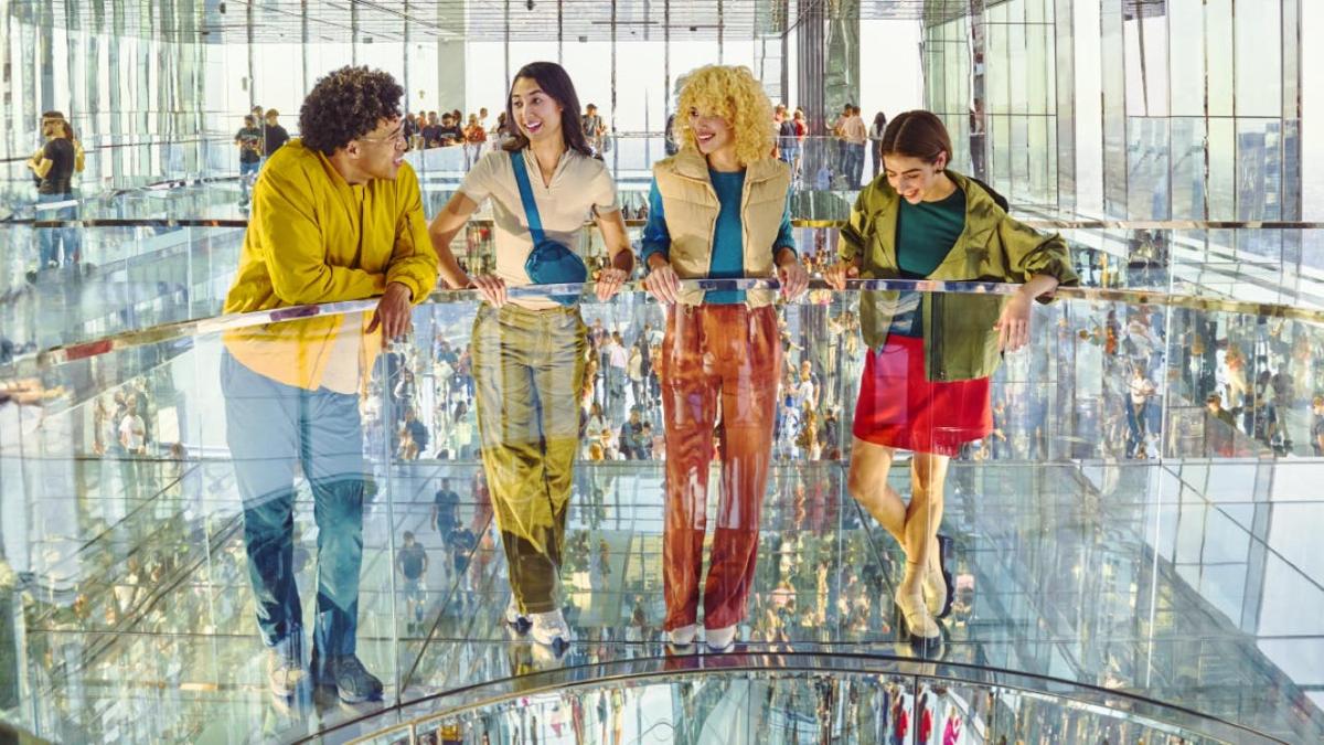 a group of women standing on a glass walkway