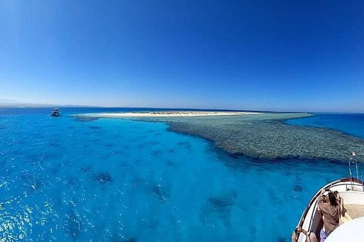 un'isola nell'oceano con una barca in acqua