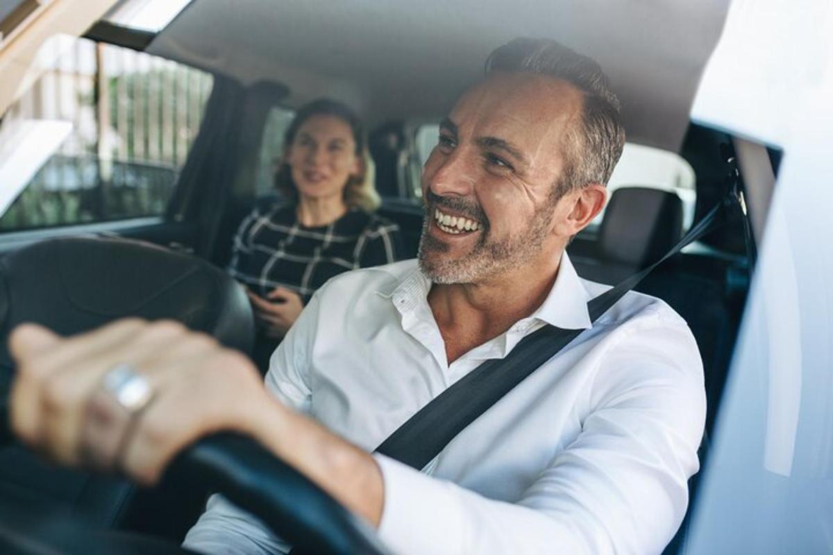 um homem está rindo enquanto está sentado em um carro